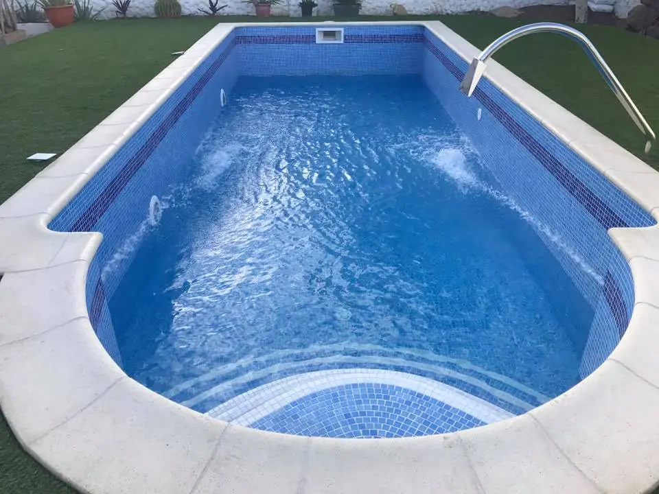 Piscina de gresite azul con escalera romana curva