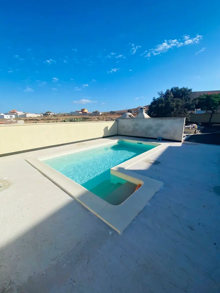 Piscina con escalera en L y zona de playa de poca profundidad