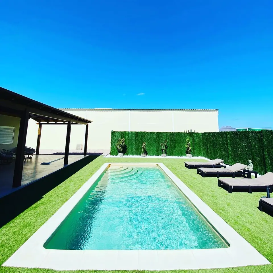 Piscina alargada con tumbonas y porche en una vivienda de Fuerteventura