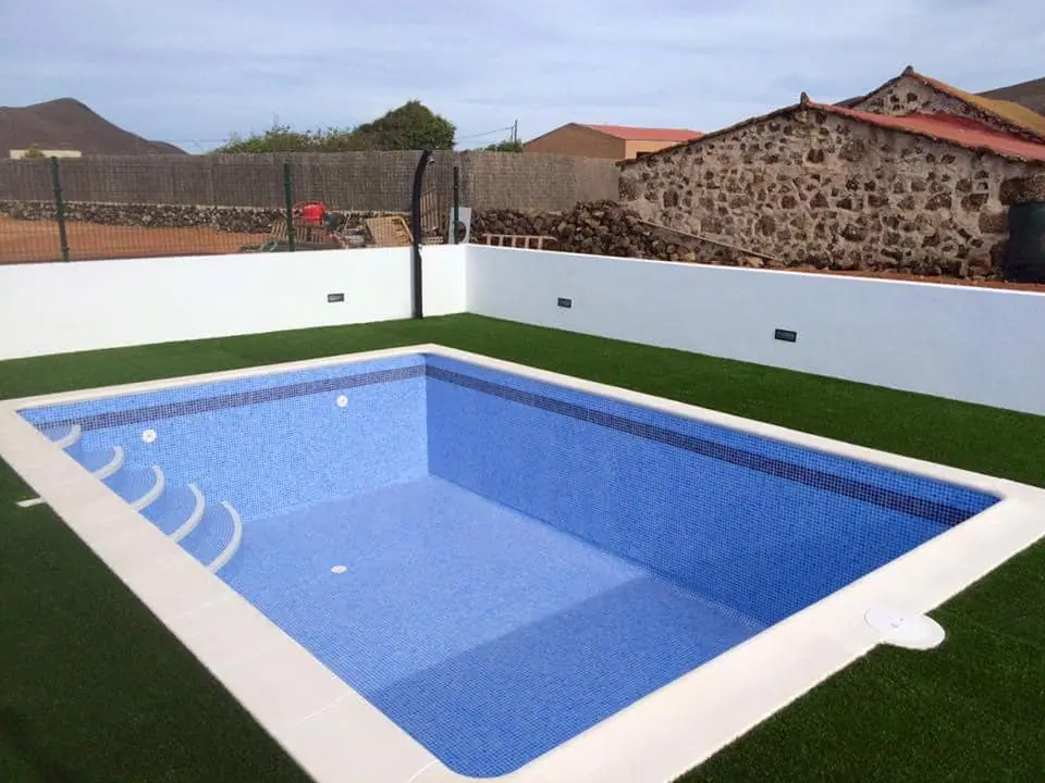 Piscina con escalera en esquina y revestimiento azul