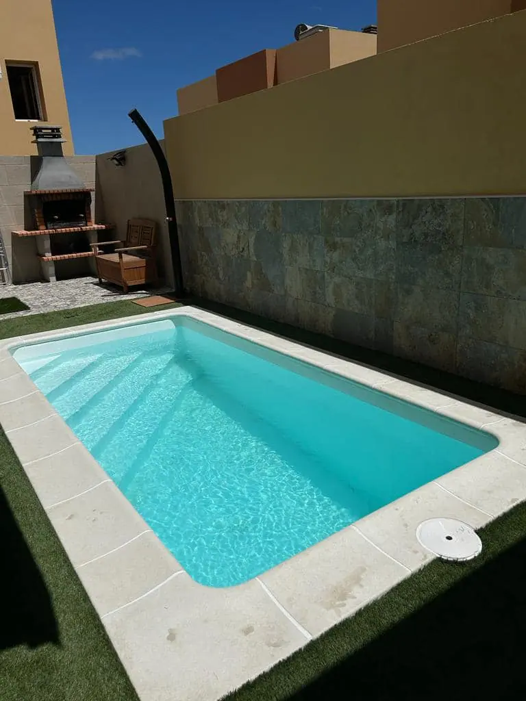 Piscina con escalera interior y pared de piedra natural
