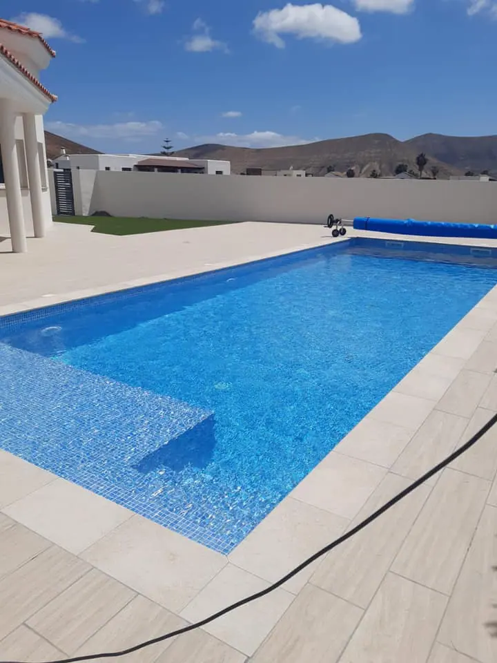 Piscina con cobertor solar y vistas a la montaña